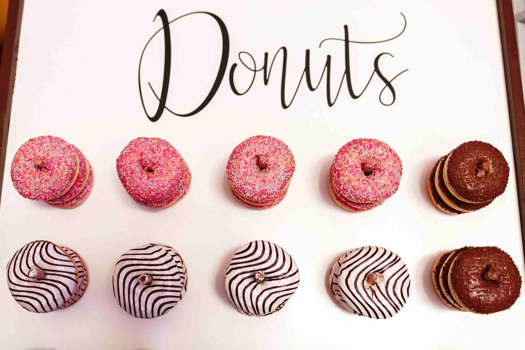 A variety of donuts, including pink frosted and chocolate frosted.