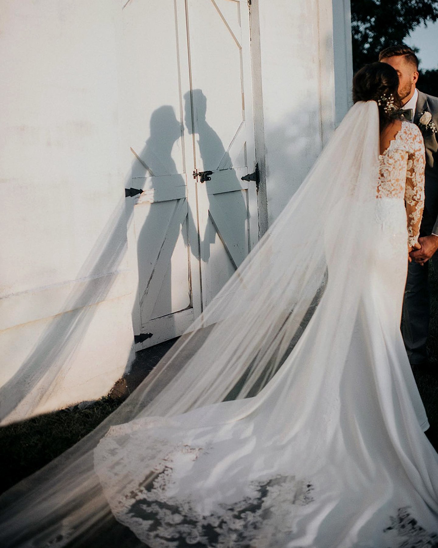 Bride wearing a white wedding dress. The bride has a long veil.