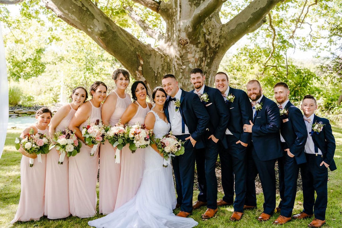 Bride and groom with bridesmaids and groomsmen outdoors.