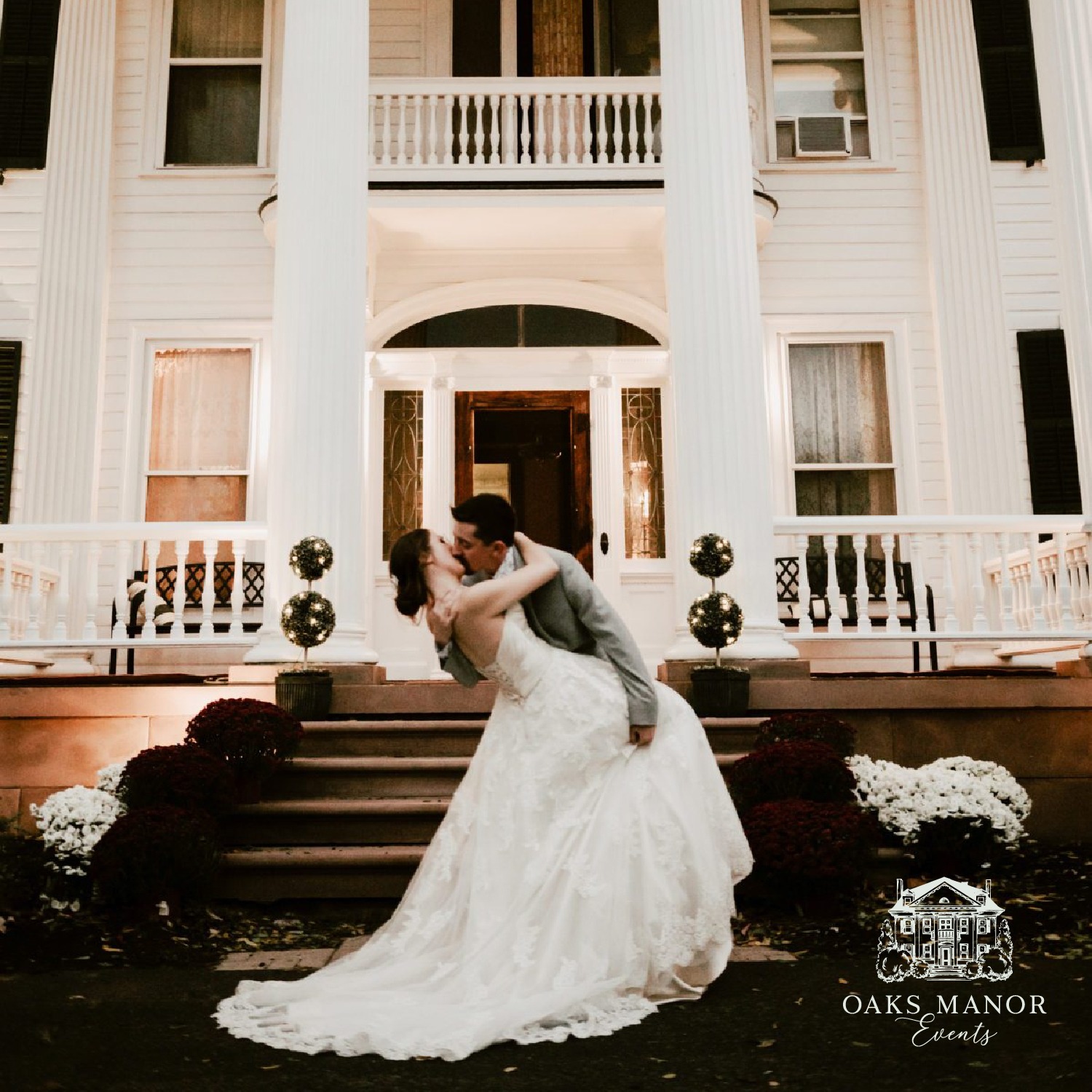 Bride and groom embracing on the steps of a grand house. The couple is sharing a tender moment.